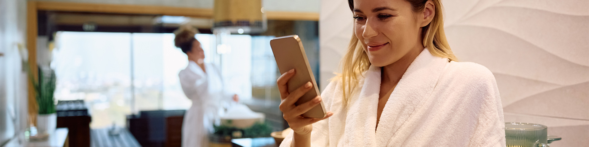 young lady in hotel room smiling at phone