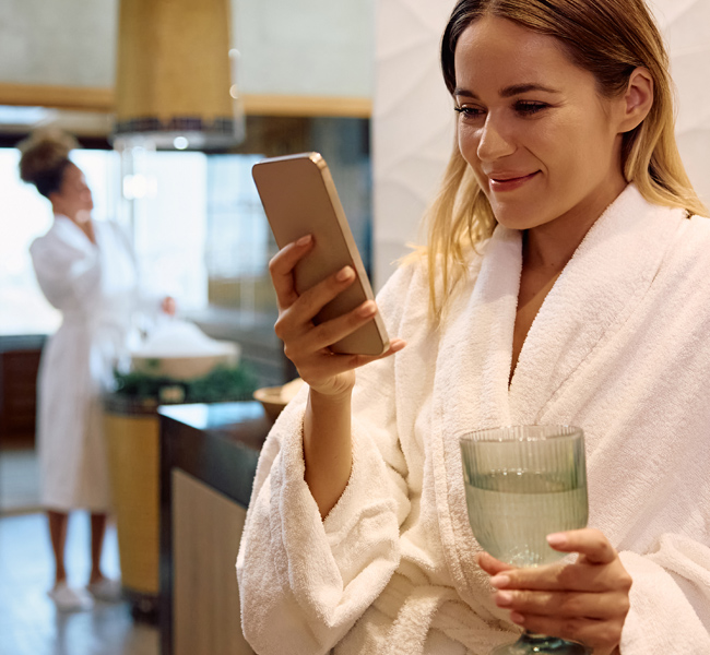 young lady in hotel room smiling at phone